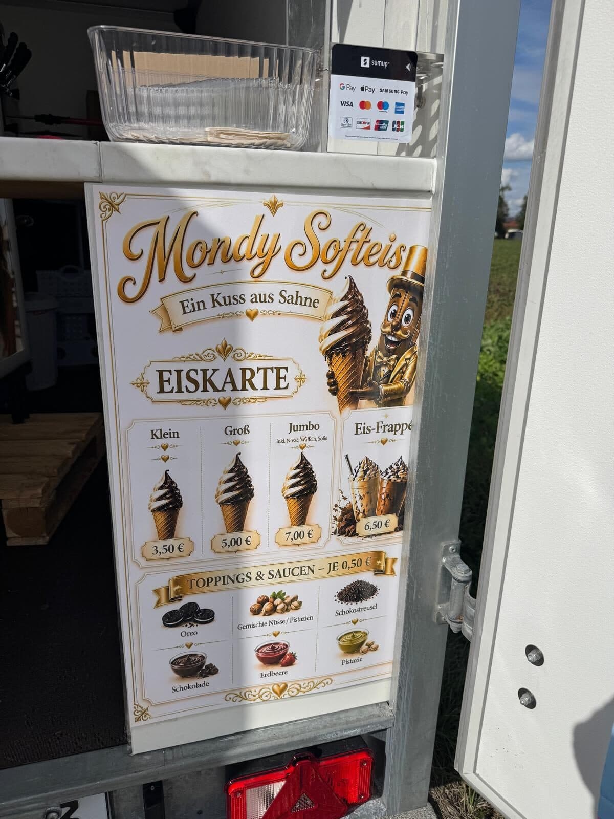 Die Eiskarte-Tafel am Wagen von Mondy Softeis: Klein 3,50 €, Groß 5,00 €, Eis-Frappé 6,50 €, Toppings & Saucen je 0,50 €, darunter das SumUp-Kartenterminal