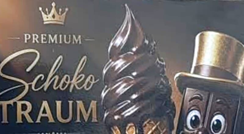 Mondys Schokomoor-Schild an der linken Seite der Theke: «Premium Schoko Traum» in goldener Schrift, daneben eine Schokoladen-Softeiswaffel und der Schokomoor mit Zylinder